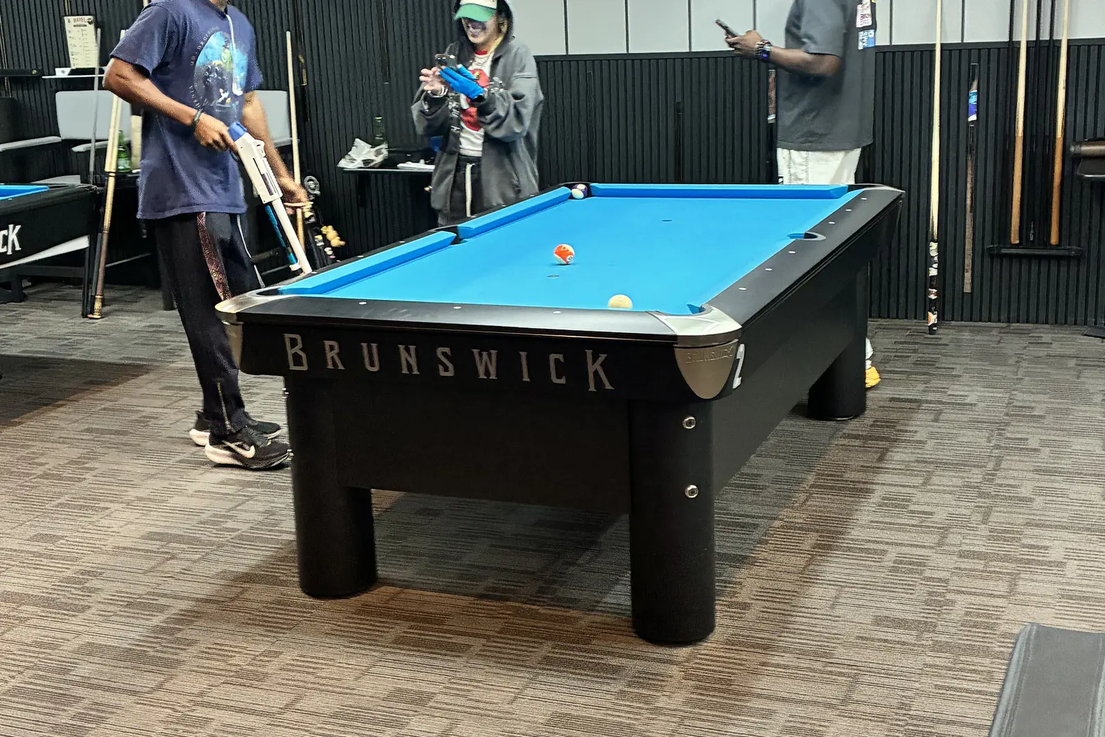 Players lining up a shot in the Komic Karma game hall